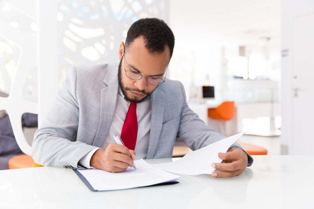 MSME owner handling regulatory compliance paperwork, illustrating challenges faced by MSMEs.
